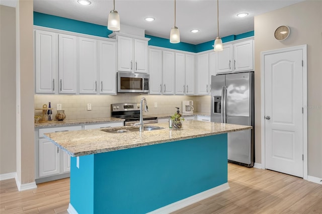 2936 Econ Landing Blvd, Orlando, FL 32825 - kitchen featuring stainless steel appliances, a sink, light wood-style flooring, backsplash, and an island with sink