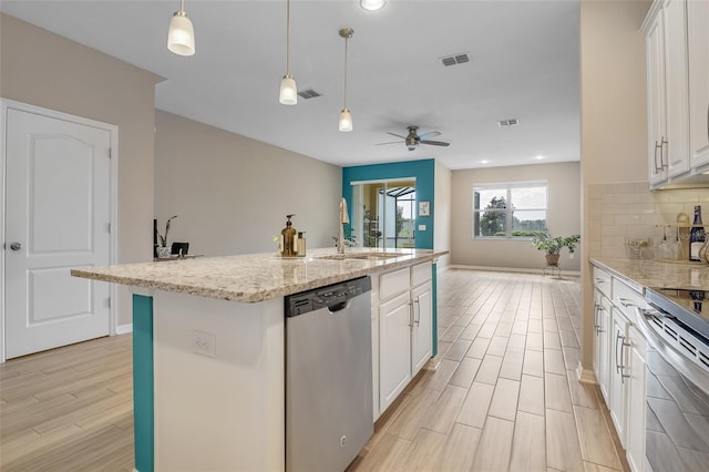2936 Econ Landing Blvd, Orlando, FL 32825 - kitchen with stainless steel appliances, a sink, white cabinets, a ceiling fan, and tasteful backsplash