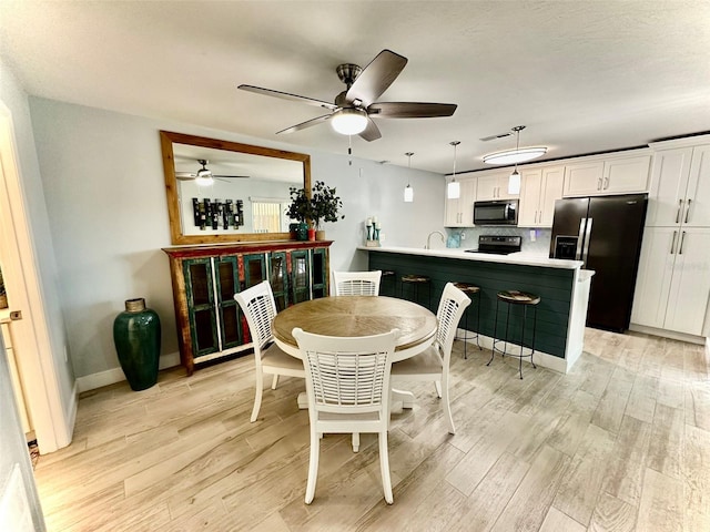 200 S Banana River Blvd Unit 703, Cocoa Beach, FL 32931 - dining space featuring a ceiling fan, light wood-style flooring, and baseboards