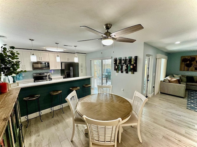 200 S Banana River Blvd Unit 703, Cocoa Beach, FL 32931 - dining space with light wood-style floors, ceiling fan, a textured ceiling, and baseboards