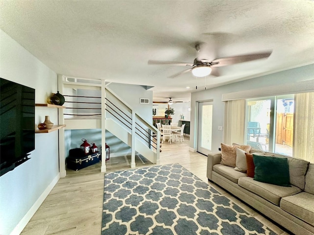 200 S Banana River Blvd Unit 703, Cocoa Beach, FL 32931 - living room with a ceiling fan, stairway, a textured ceiling, wood finished floors, and baseboards