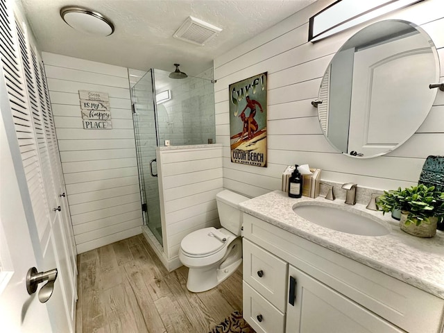 200 S Banana River Blvd Unit 703, Cocoa Beach, FL 32931 - full bath with wood finished floors, vanity, a stall shower, toilet, and wood walls