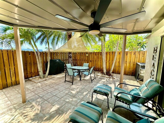 200 S Banana River Blvd Unit 703, Cocoa Beach, FL 32931 - fenced backyard featuring a patio, outdoor dining space, grilling area, and ceiling fan