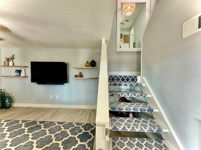 200 S Banana River Blvd Unit 703, Cocoa Beach, FL 32931 - stairway with wood finished floors, baseboards, and a textured ceiling