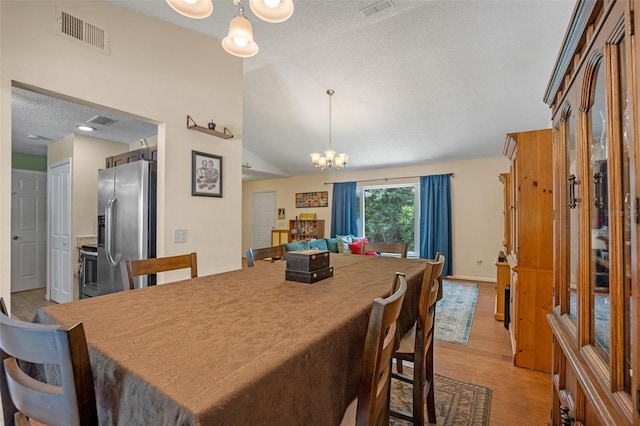 3362 Partridge St, Deltona, FL 32738 - dining room with a chandelier, lofted ceiling, light wood-style floors, and a textured ceiling