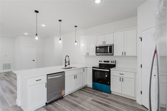 17434 SW 36th Avenue Rd, Ocala, FL 34473 - kitchen with stainless steel appliances, a sink, a peninsula, light countertops, and white cabinetry