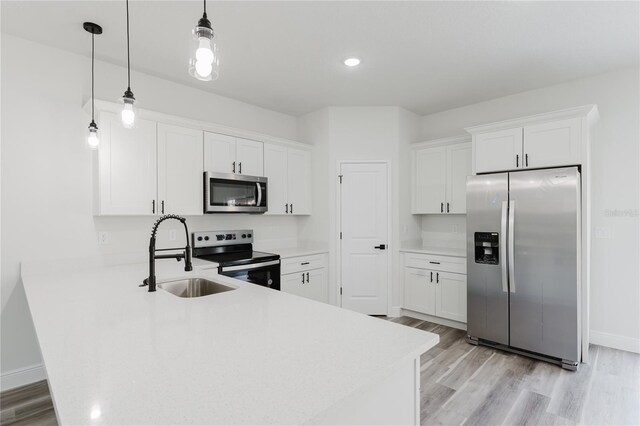 17434 SW 36th Avenue Rd, Ocala, FL 34473 - kitchen with stainless steel appliances, a sink, a peninsula, light wood-style floors, and light countertops
