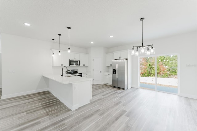 17434 SW 36th Avenue Rd, Ocala, FL 34473 - kitchen with appliances with stainless steel finishes, a sink, baseboards, a peninsula, and light wood-style flooring