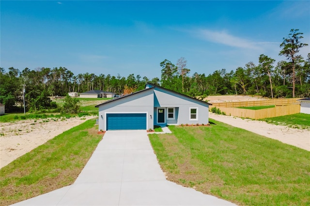 17434 SW 36th Avenue Rd, Ocala, FL 34473 - view of front facade with a garage, driveway, stucco siding, and view of scattered trees