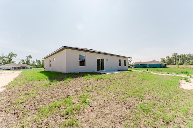 17434 SW 36th Avenue Rd, Ocala, FL 34473 - rear view of property with stucco siding, a yard, and a patio