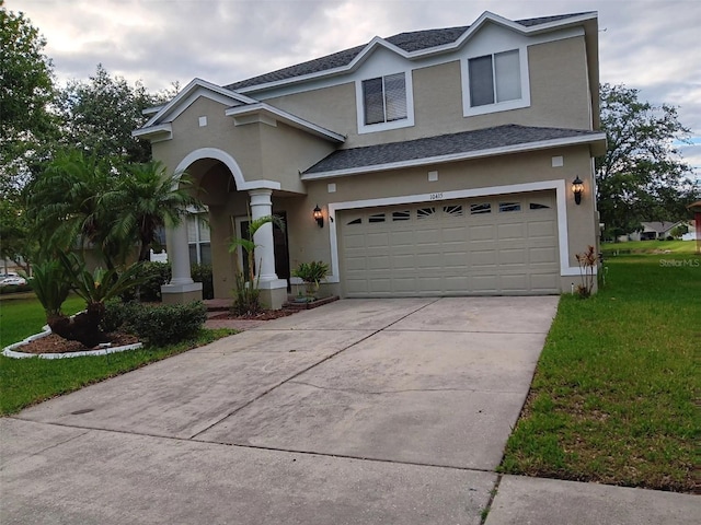 10415 Lucaya Dr, Tampa, FL 33647 - traditional home featuring stucco siding, a garage, a front lawn, concrete driveway, and roof with shingles