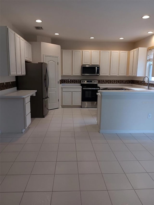 10415 Lucaya Dr, Tampa, FL 33647 - kitchen featuring stainless steel appliances, a sink, light tile patterned floors, recessed lighting, and white cabinetry