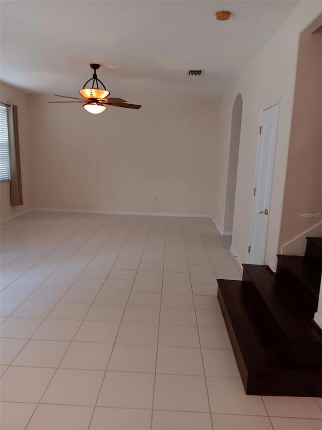 10415 Lucaya Dr, Tampa, FL 33647 - empty room with a ceiling fan, stairs, a smoke detector, light tile patterned floors, and arched walkways