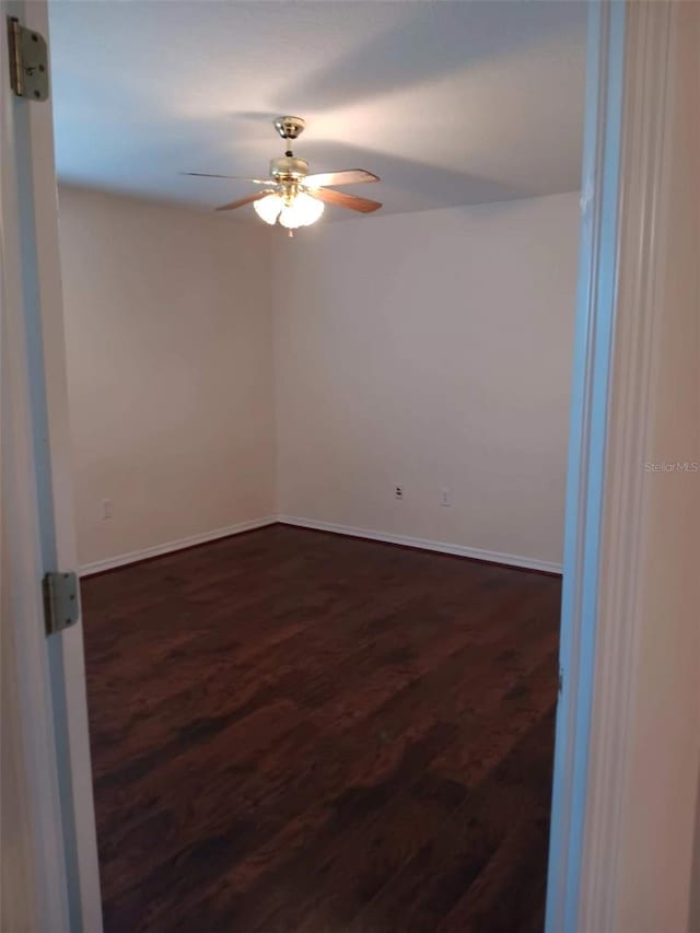 10415 Lucaya Dr, Tampa, FL 33647 - spare room with dark wood-style floors, a ceiling fan, and baseboards