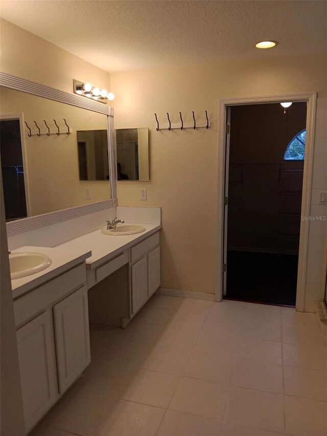 10415 Lucaya Dr, Tampa, FL 33647 - full bathroom featuring double vanity, a walk in closet, tile patterned flooring, a textured ceiling, and recessed lighting