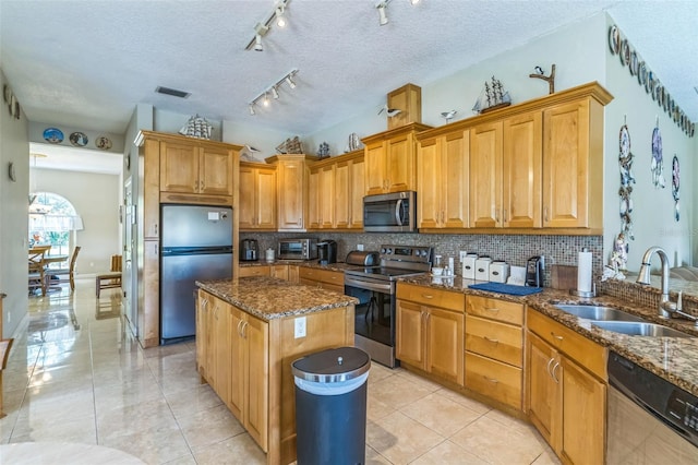 34239 Woodridge Ln, Eustis, FL 32736 - kitchen with stainless steel appliances, a sink, decorative backsplash, a center island, and dark stone countertops