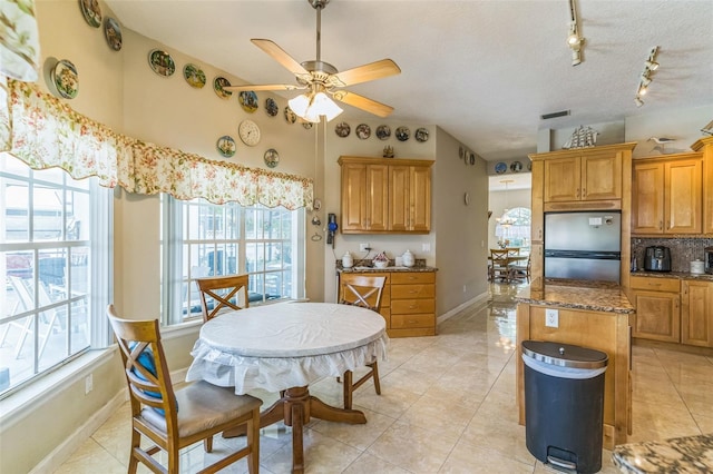 34239 Woodridge Ln, Eustis, FL 32736 - kitchen with freestanding refrigerator, rail lighting, a ceiling fan, a center island, and backsplash