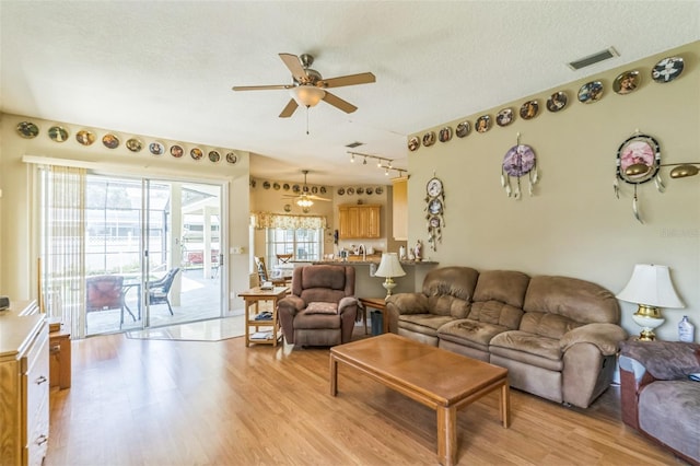 34239 Woodridge Ln, Eustis, FL 32736 - living room featuring light wood-style flooring, a ceiling fan, a textured ceiling, and rail lighting