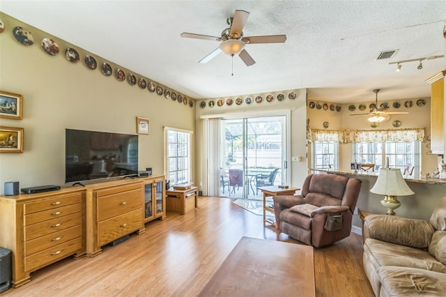34239 Woodridge Ln, Eustis, FL 32736 - living area featuring ceiling fan, light wood-style floors, and a textured ceiling
