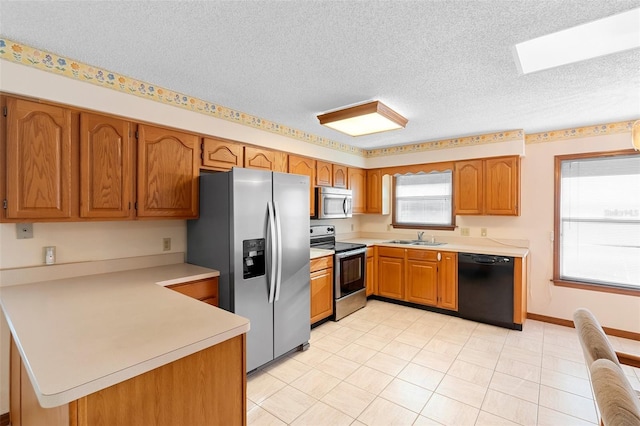 2018 N Normandy Blvd, Deltona, FL 32725 - kitchen with appliances with stainless steel finishes, a sink, a peninsula, a textured ceiling, and light countertops