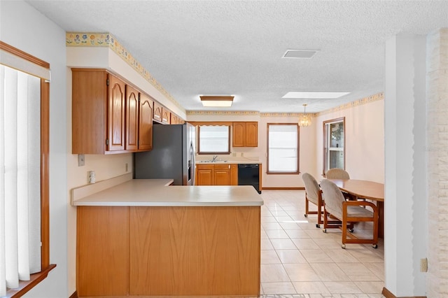 2018 N Normandy Blvd, Deltona, FL 32725 - kitchen featuring black dishwasher, stainless steel fridge, light countertops, a textured ceiling, and a sink
