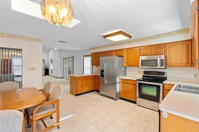 2018 N Normandy Blvd, Deltona, FL 32725 - kitchen featuring appliances with stainless steel finishes, a chandelier, light countertops, a sink, and a textured ceiling