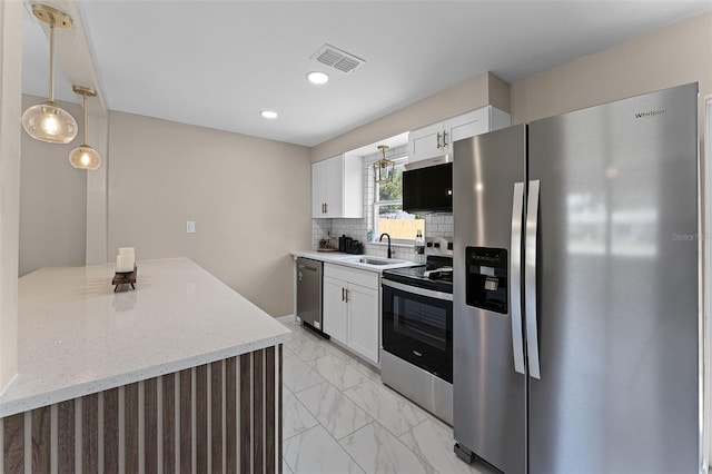 410 W Seminole Ave, Eustis, FL 32726 - kitchen with stainless steel appliances, light marble finish floors, white cabinets, tasteful backsplash, and pendant lighting