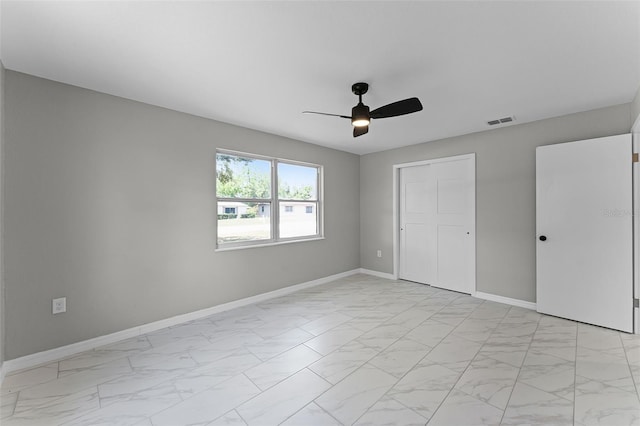 410 W Seminole Ave, Eustis, FL 32726 - unfurnished bedroom with light marble finish flooring, baseboards, ceiling fan, and a closet