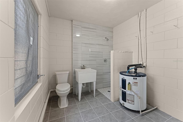 410 W Seminole Ave, Eustis, FL 32726 - bathroom with water heater, a walk in shower, toilet, tile walls, and tile patterned flooring