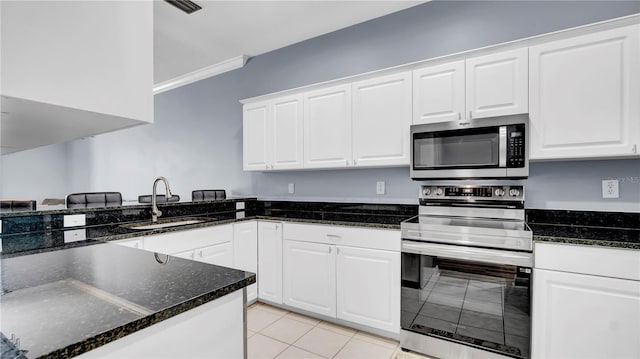 5016 W Lancaster St Unit 00, Tampa, FL 33616 - kitchen featuring stainless steel appliances, a sink, white cabinetry, light tile patterned floors, and dark stone counters