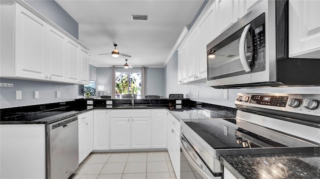 5016 W Lancaster St Unit 00, Tampa, FL 33616 - kitchen featuring appliances with stainless steel finishes, ceiling fan, light tile patterned flooring, a sink, and white cabinets