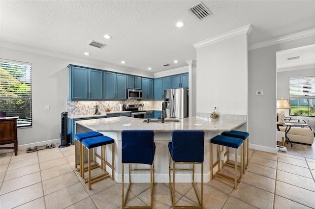 1716 Wild Indigo Ter, Oviedo, FL 32766 - kitchen with stainless steel appliances, blue cabinetry, a peninsula, a sink, and a breakfast bar