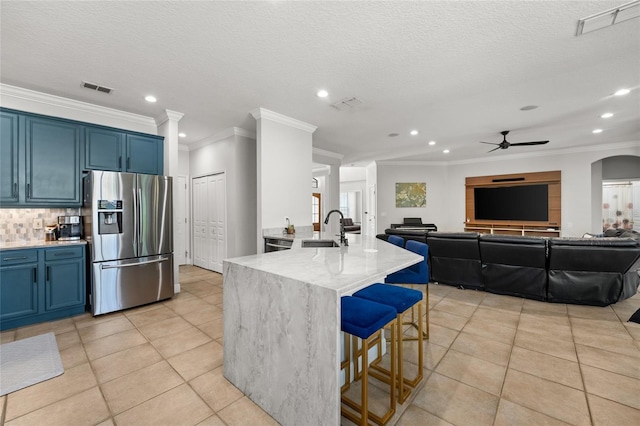 1716 Wild Indigo Ter, Oviedo, FL 32766 - kitchen featuring stainless steel refrigerator with ice dispenser, a sink, blue cabinetry, ornamental molding, and ceiling fan
