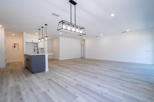 509 St Johns Ct, Poinciana, FL 34759 - kitchen with open floor plan, recessed lighting, light countertops, light wood-style floors, and pendant lighting