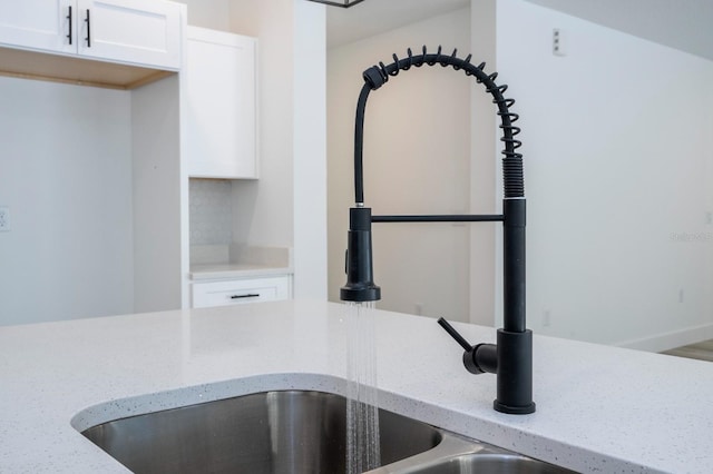 509 St Johns Ct, Poinciana, FL 34759 - kitchen view of light stone counters, white cabinetry, and a sink