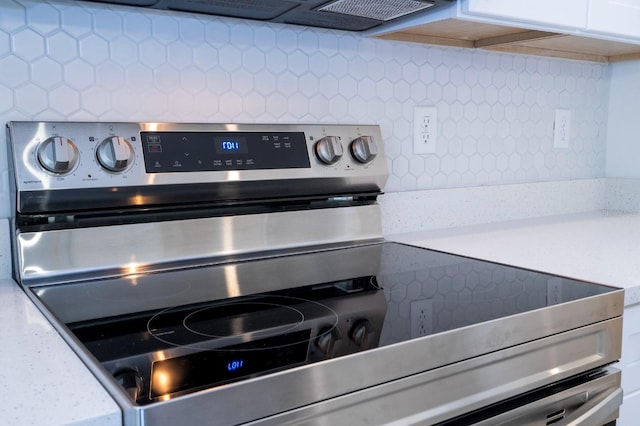 509 St Johns Ct, Poinciana, FL 34759 - kitchen view of stainless steel electric range oven, backsplash, light countertops, and white cabinets
