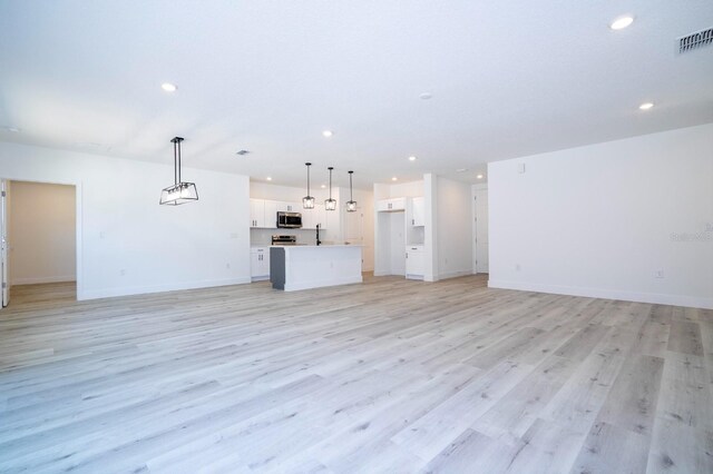 509 St Johns Ct, Poinciana, FL 34759 - unfurnished living room featuring recessed lighting, baseboards, and light wood finished floors