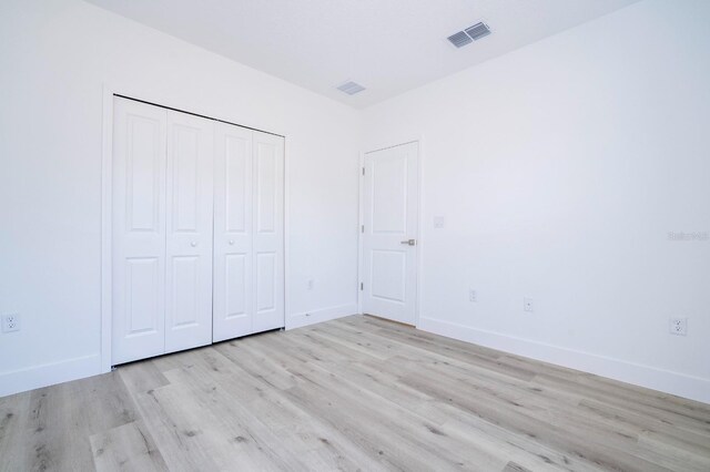 509 St Johns Ct, Poinciana, FL 34759 - unfurnished bedroom featuring light wood-type flooring, a closet, and baseboards