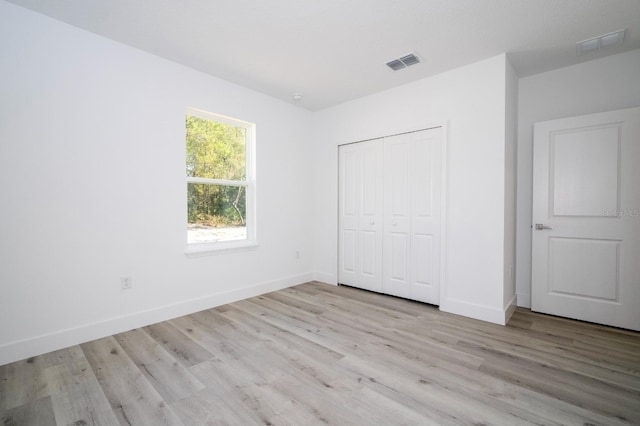 509 St Johns Ct, Poinciana, FL 34759 - unfurnished bedroom with light wood-style floors, baseboards, and a closet