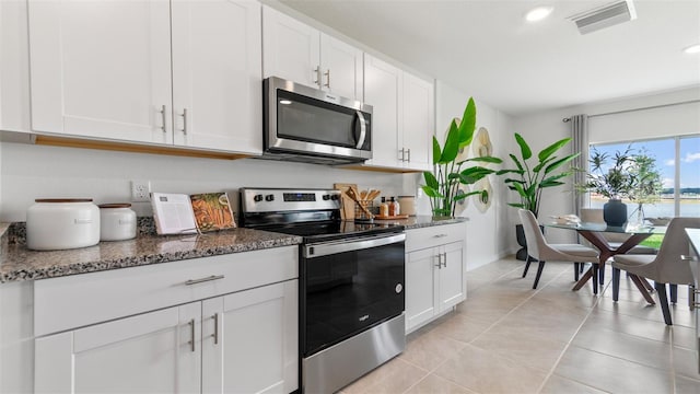 1495 Fountain View St, Ormond Beach, FL 32174 - kitchen with appliances with stainless steel finishes, dark stone countertops, white cabinetry, and recessed lighting