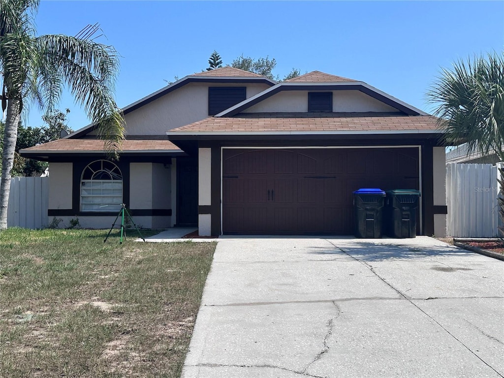 6554 Meritmoor Cir, Orlando, FL 32818 - ranch-style home featuring stucco siding, an attached garage, concrete driveway, and roof with shingles
