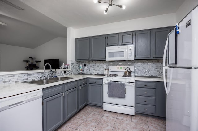 3832 NW 27th St, Gainesville, FL 32605 - kitchen featuring white appliances, a sink, gray cabinets, vaulted ceiling, and backsplash