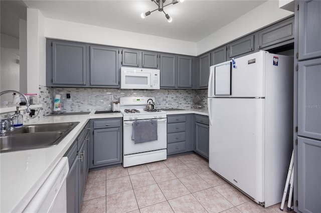 3832 NW 27th St, Gainesville, FL 32605 - kitchen with white appliances, a sink, backsplash, gray cabinetry, and light tile patterned flooring