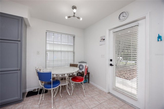 3832 NW 27th St, Gainesville, FL 32605 - dining area featuring plenty of natural light, baseboards, light tile patterned floors, and a chandelier