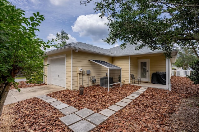 3832 NW 27th St, Gainesville, FL 32605 - back of house featuring central AC, driveway, a shingled roof, and an attached garage