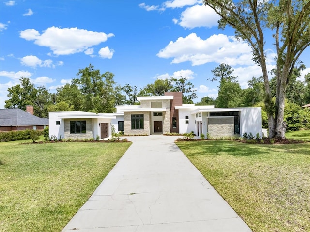 7615 SE 12th Cir, Ocala, FL 34480 - modern home with stone siding, concrete driveway, a front lawn, and a chimney