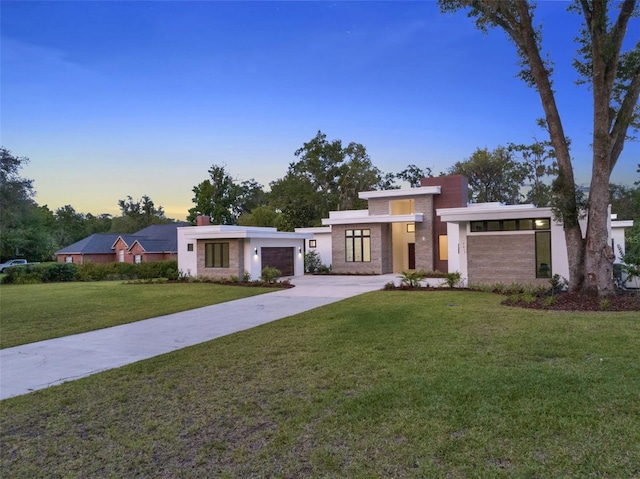 7615 SE 12th Cir, Ocala, FL 34480 - contemporary house featuring concrete driveway, a front lawn, an attached garage, stucco siding, and stone siding