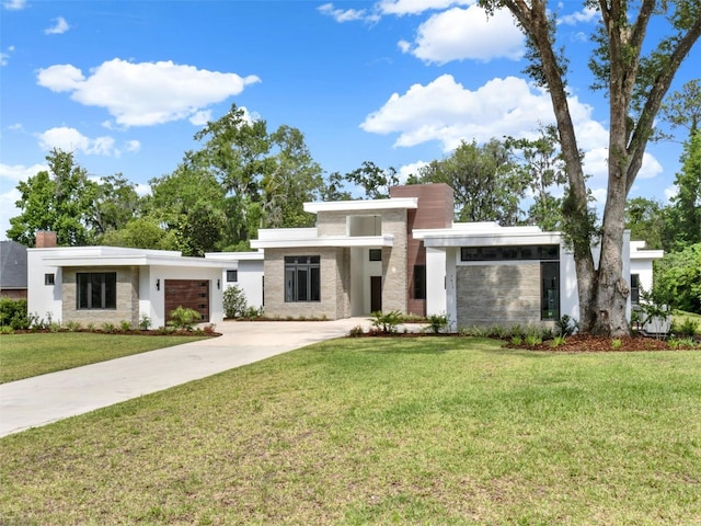 7615 SE 12th Cir, Ocala, FL 34480 - contemporary house featuring an attached garage, concrete driveway, a chimney, stucco siding, and a front yard