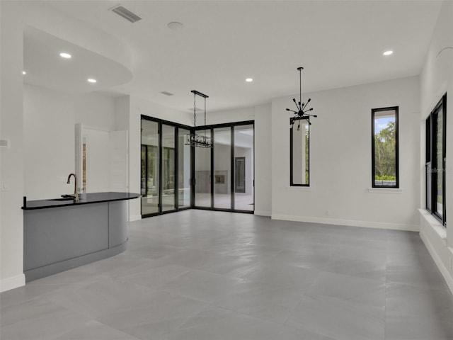 7615 SE 12th Cir, Ocala, FL 34480 - unfurnished living room with a chandelier, recessed lighting, a sink, and baseboards