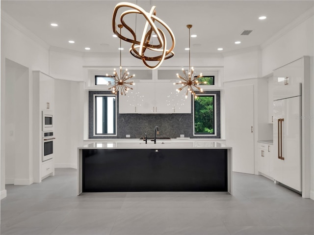 7615 SE 12th Cir, Ocala, FL 34480 - kitchen with built in appliances, a chandelier, modern cabinets, white cabinetry, and a sink